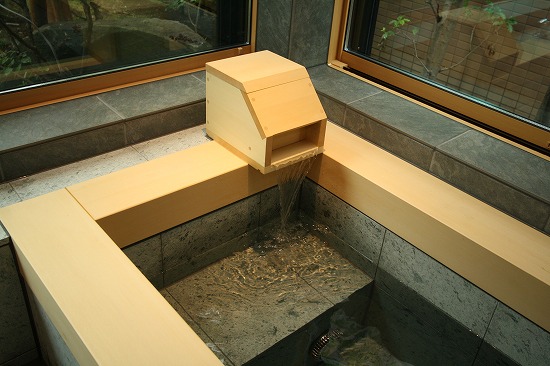 天然ヒノキの吐水口から流れ出るお湯。