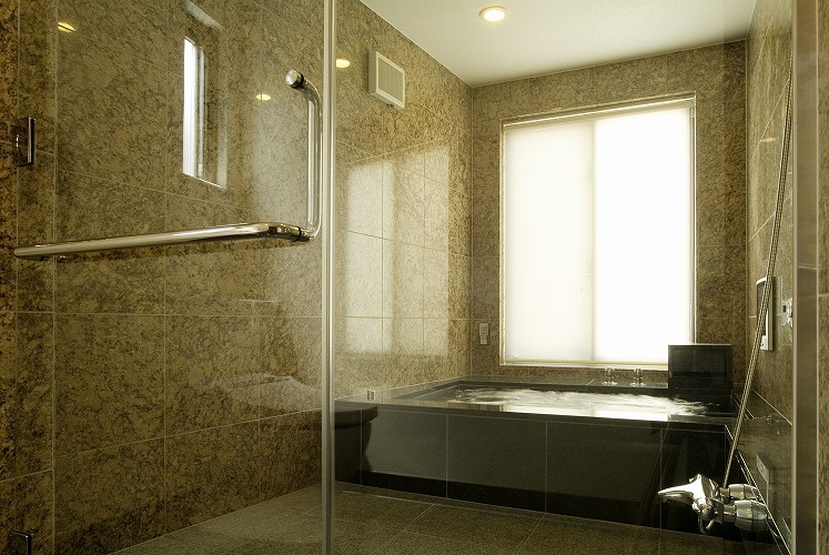 大きな窓から外を眺めることができます。 窓の周りは、壁と同じ御影石で巻き込んでいます。ユニットバスのような樹脂枠は使用していません。