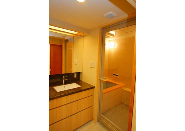 こだわりポイントNO.1の浴槽がちらっと見えます。浴槽の天然檜框と洗面化粧台のとてもよくマッチしています。