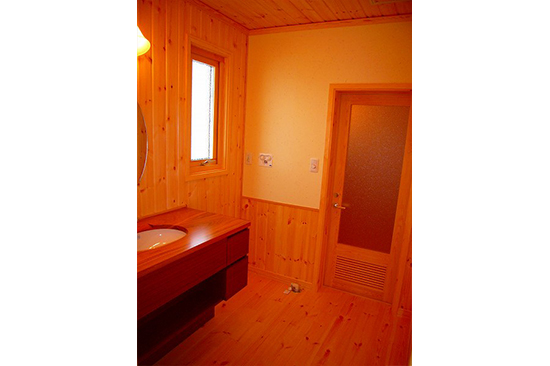 洗面室からお風呂を見ています。お風呂のドアも檜で特別に製作しました。