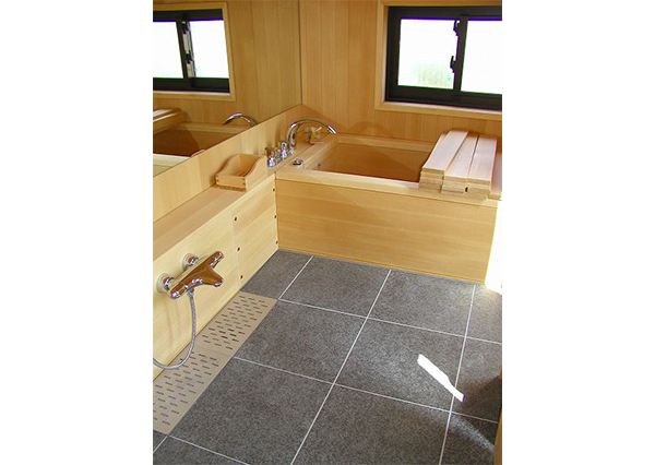 天然ヒバ材の浴槽には、風呂ふたもヒバ材で創っています。床は、黒御影石のジェットバーナー仕上げです。