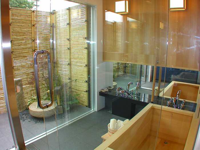 浴槽の横には、シャワーブースを設置しました。ヘアラインステンレスの枠の透明ガラスドアとFIXで間仕切りしています。