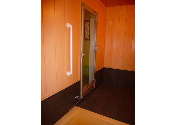 ドアは、耐久性と機能性を考えてアルミ製のドアを採用。透明ガラスを使用しています。壁と天井の仕上げ材には、木調のバスパネルを採用しています。
