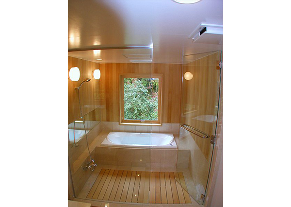 洗面室の天井と浴槽の天井は、同じ高さで同じ材質で仕上げています。透明ガラスのドア部分はステンレスの枠がないタイプ、FIX部もステンレスの枠がほとんど主張していないので、スッキリした仕上がりになっています。