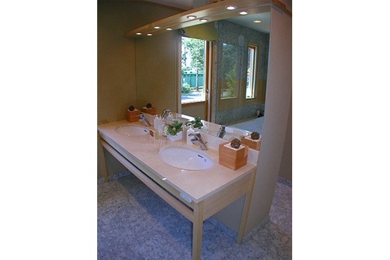 洗面化粧台は、ベージュ系の大理石のカウンター。脚部は、浴室に採用したヒバ材と同じものです。