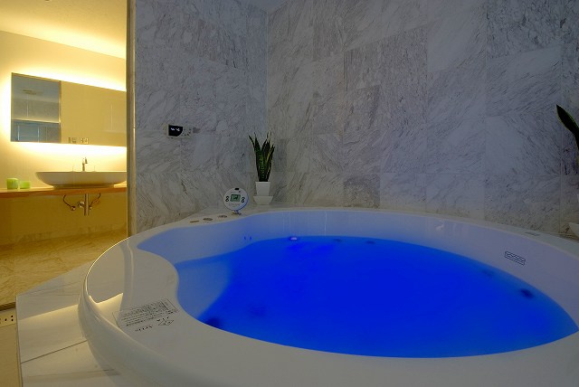 深いブルー色を湛えたバスタブから洗面室を。