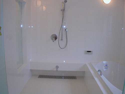 洗面室より浴室のドアを見ています。ドア枠が見えない仕上げは、とっても上品なイメージです。