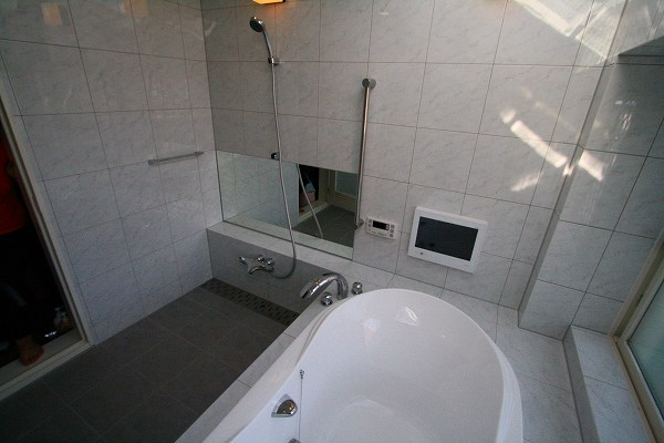 壁の仕上げは、大理石調のタイルです。鏡は洗い場の幅と同じサイズの物を取り付けています。