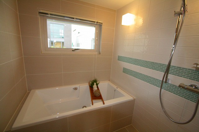 ホワイトタイルにブルーのモザイクタイルが印象的なバスルームです。