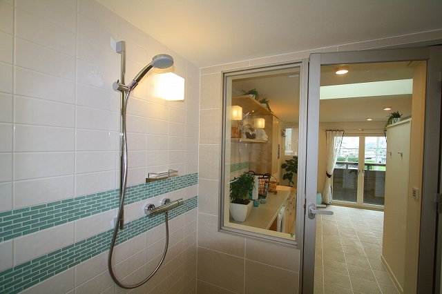 浴室から透明ガラスで仕切られた洗面室エリアを臨みます。