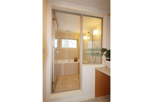 洗面室との間仕切りには、アルミ框のドアとFIXを採用しています。