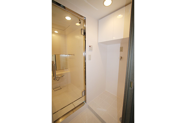 洗濯機を置くコーナー。吊戸棚は間取りに合わせて製作しました。