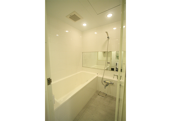 壁はホワイトのタイル、床はサーモタイルで仕上げています。浴槽は、TOTO社製「ラフィア」。