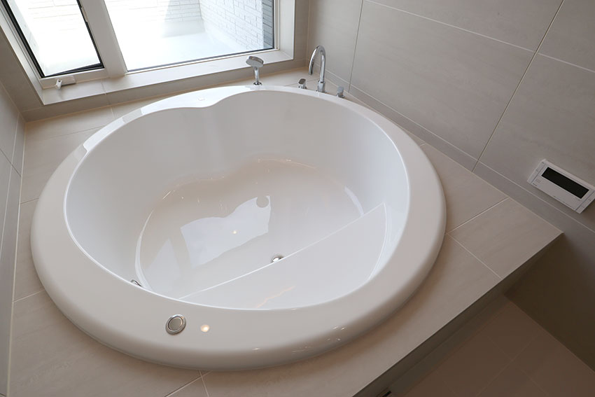 浴室の窓から見える大海原 円形浴槽とオーバーヘッドシャワーそして透明ガラスドア