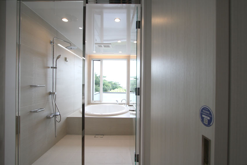 浴室の窓から見える大海原 円形浴槽とオーバーヘッドシャワーそして透明ガラスドア