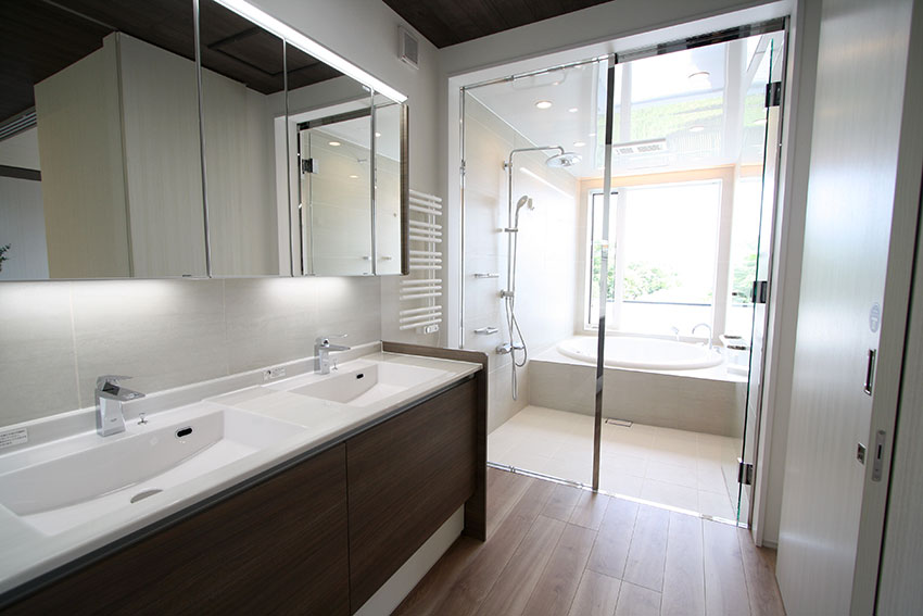 浴室の窓から見える大海原 円形浴槽とオーバーヘッドシャワーそして透明ガラスドア